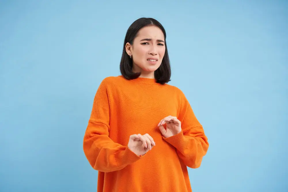 fundo azul, mulher com uma roupa laranja com cara de medo